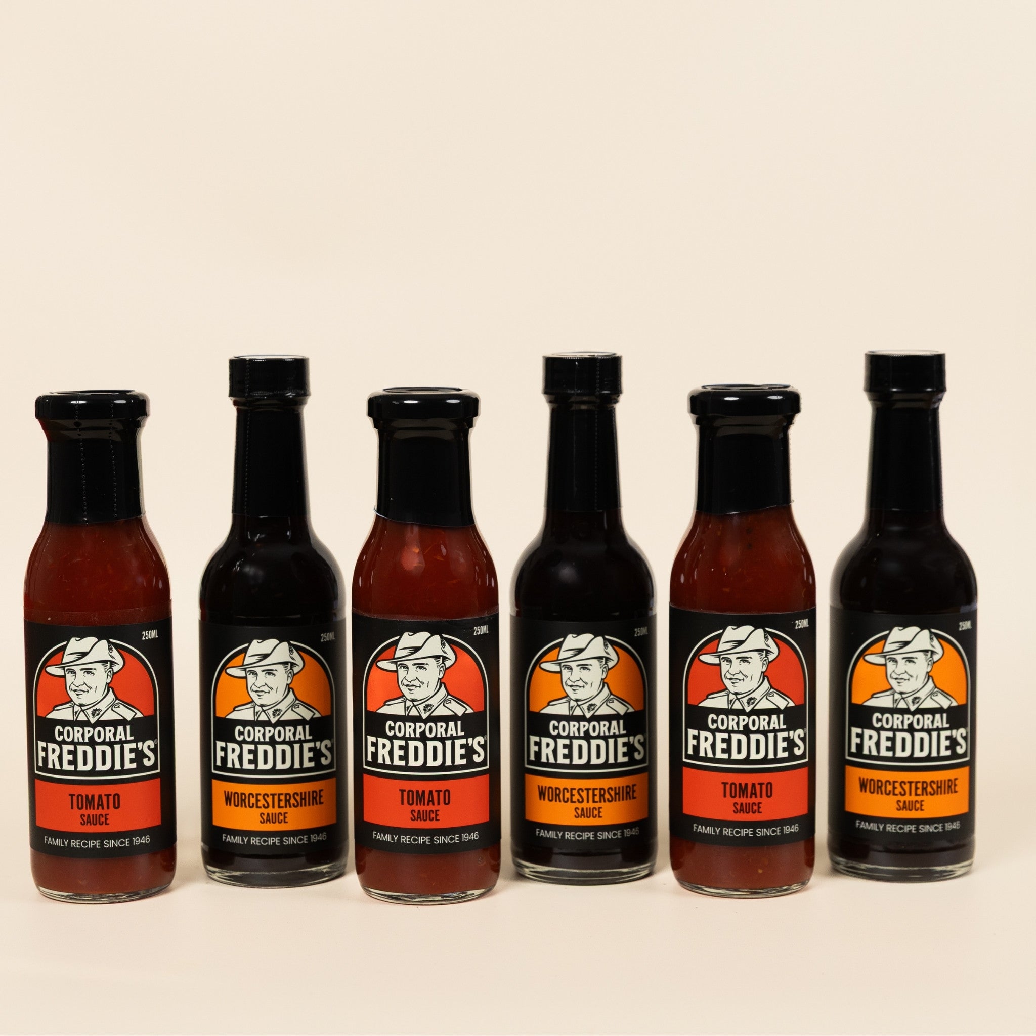 Six bottles of Corporal Freddie's sauces on a beige background