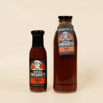 Two bottles of Corporal Freddie's Tomato Sauce on a beige background