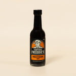 Bottle of Corporal Freddie's Worcestershire sauce on a beige background