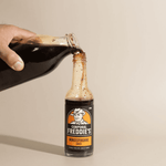 Worcestershire sauce being poured from one bottle into another