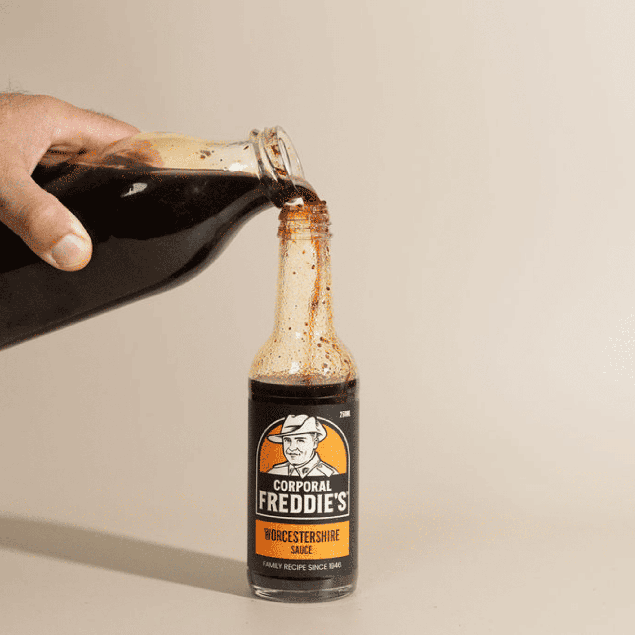 Worcestershire sauce being poured from one bottle into another